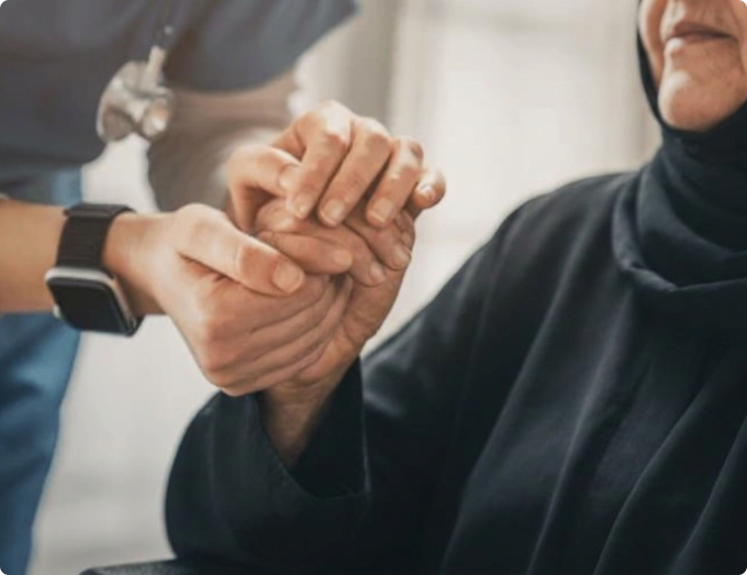 Healthcare professional holding the hands of an elderly lupus patient